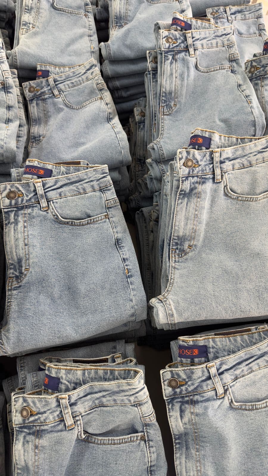 Folded blue jeans stacked on a retail display