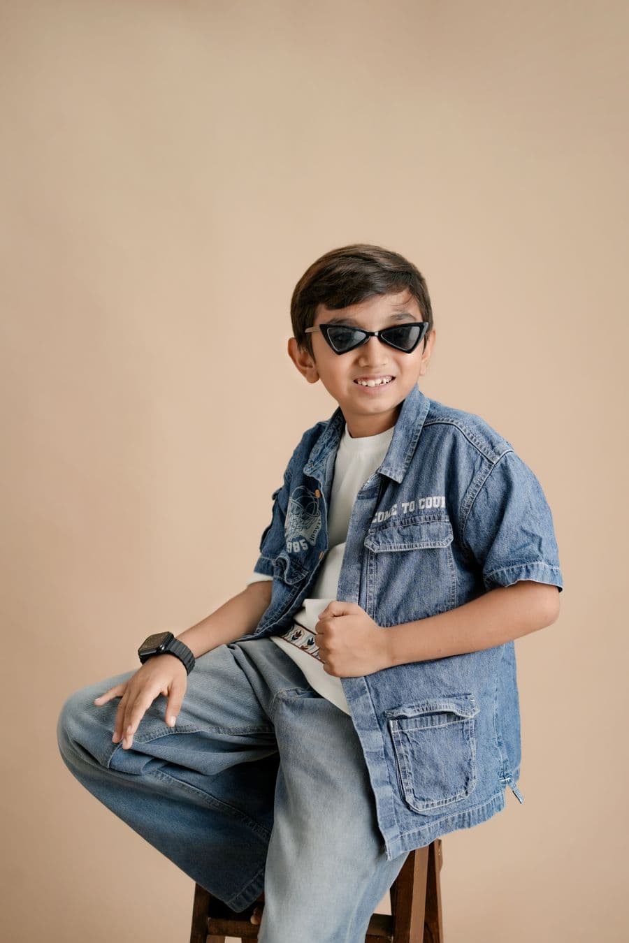 Child wearing a denim jacket and sunglasses