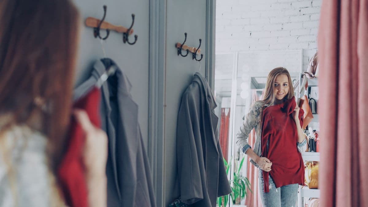 Smiling customer holding a garment while shopping