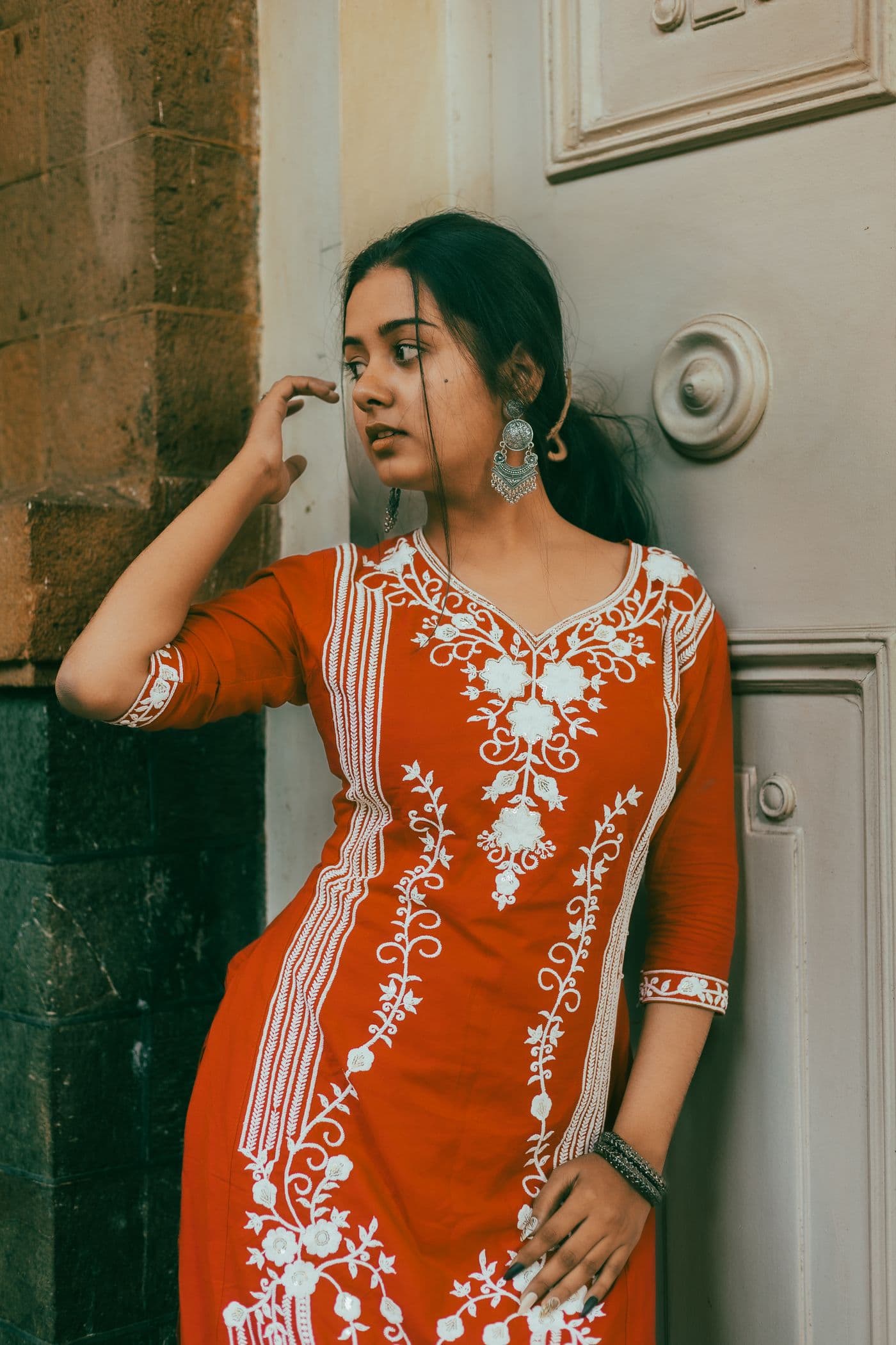 Woman wearing a red printed cotton kurti with white embroidery
